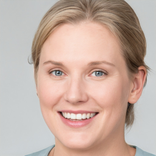 Joyful white adult female with medium  brown hair and blue eyes