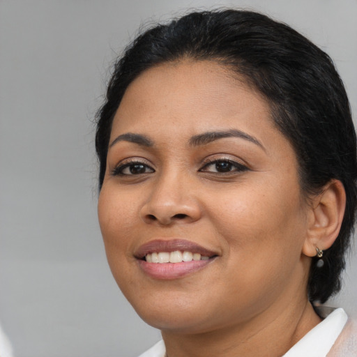 Joyful latino young-adult female with medium  brown hair and brown eyes