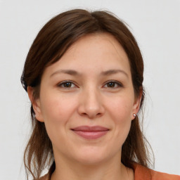 Joyful white young-adult female with medium  brown hair and grey eyes