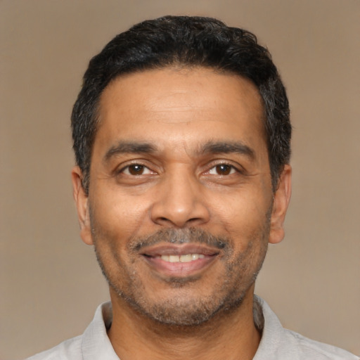 Joyful black adult male with short  black hair and brown eyes