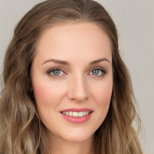 Joyful white young-adult female with long  brown hair and blue eyes