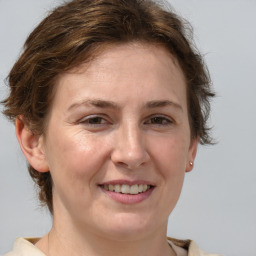 Joyful white adult female with medium  brown hair and blue eyes