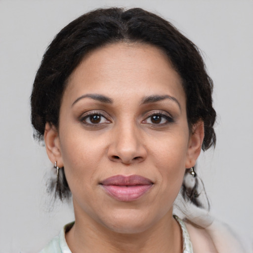 Joyful latino adult female with medium  brown hair and brown eyes
