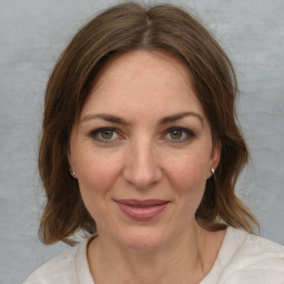 Joyful white young-adult female with medium  brown hair and blue eyes