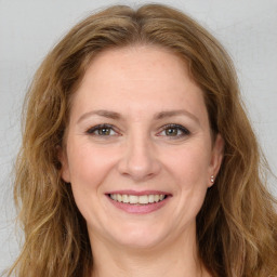 Joyful white young-adult female with long  brown hair and green eyes