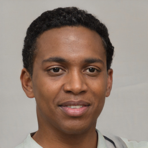 Joyful black young-adult male with short  black hair and brown eyes