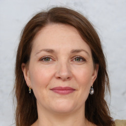 Joyful white adult female with long  brown hair and grey eyes