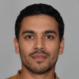 Joyful latino young-adult male with short  brown hair and brown eyes