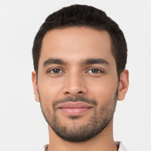 Joyful latino young-adult male with short  brown hair and brown eyes