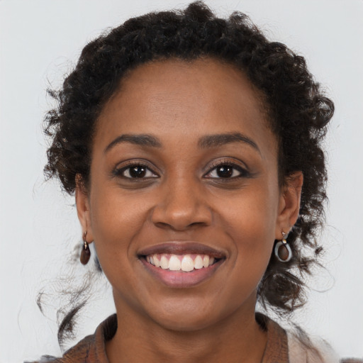 Joyful black young-adult female with long  brown hair and brown eyes