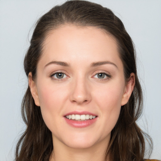 Joyful white young-adult female with long  brown hair and grey eyes