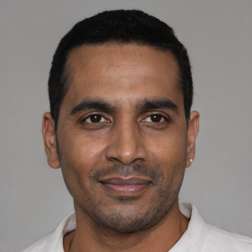 Joyful black young-adult male with short  black hair and brown eyes