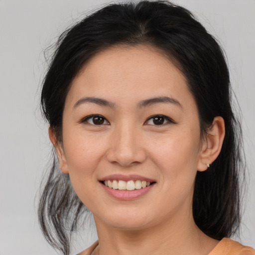 Joyful asian young-adult female with medium  brown hair and brown eyes