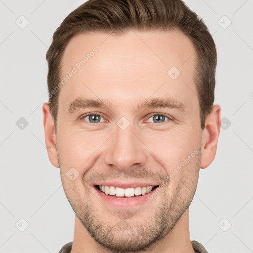 Joyful white young-adult male with short  brown hair and grey eyes