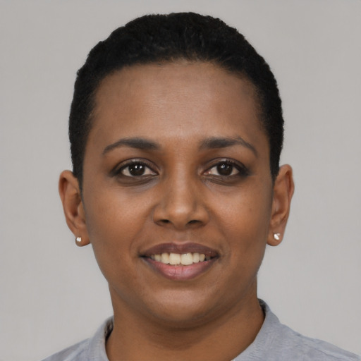 Joyful black young-adult female with short  black hair and brown eyes