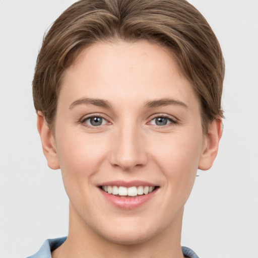 Joyful white young-adult female with short  brown hair and grey eyes