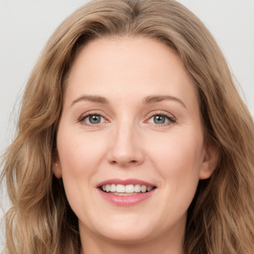 Joyful white young-adult female with long  brown hair and green eyes