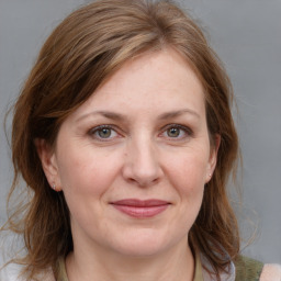 Joyful white adult female with medium  brown hair and grey eyes