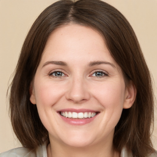 Joyful white young-adult female with medium  brown hair and grey eyes