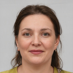 Joyful white adult female with medium  brown hair and grey eyes