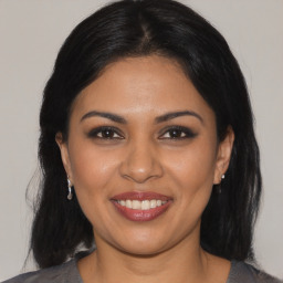 Joyful latino young-adult female with medium  brown hair and brown eyes