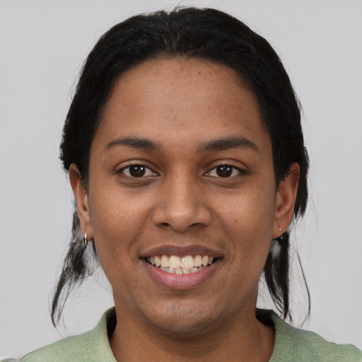 Joyful black young-adult female with short  black hair and brown eyes