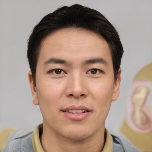 Joyful asian young-adult male with short  brown hair and brown eyes