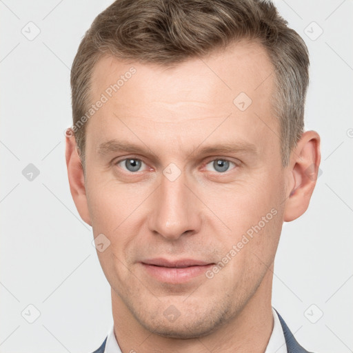 Joyful white young-adult male with short  brown hair and grey eyes