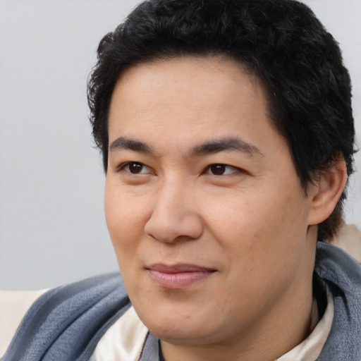 Joyful latino young-adult male with short  brown hair and brown eyes