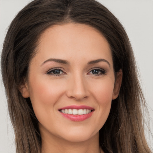 Joyful white young-adult female with long  brown hair and brown eyes