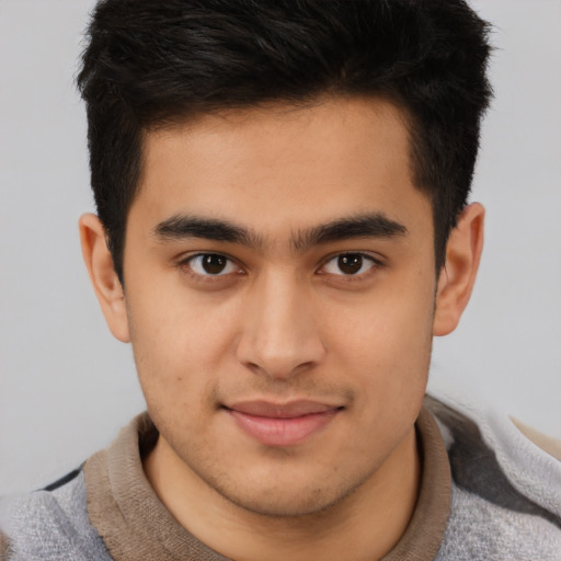 Joyful latino young-adult male with short  brown hair and brown eyes