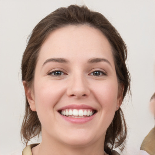 Joyful white young-adult female with medium  brown hair and grey eyes