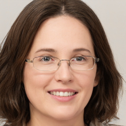 Joyful white young-adult female with long  brown hair and green eyes