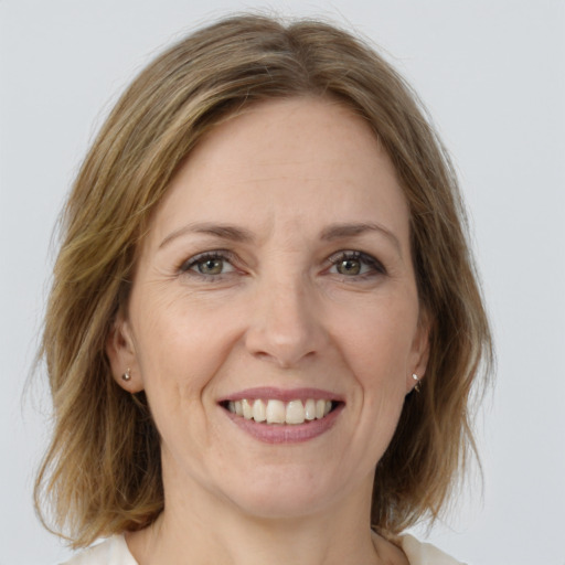 Joyful white adult female with medium  brown hair and green eyes