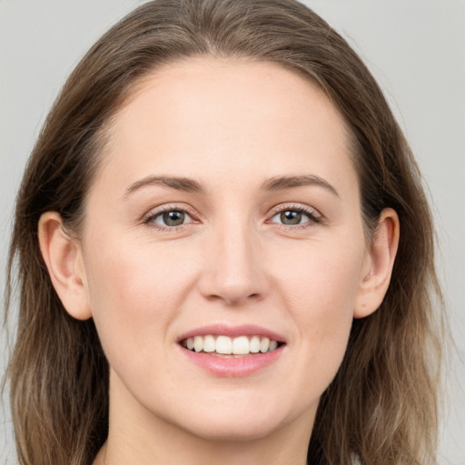 Joyful white young-adult female with long  brown hair and grey eyes