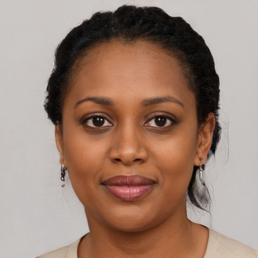 Joyful black young-adult female with short  black hair and brown eyes