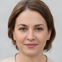 Joyful white young-adult female with medium  brown hair and grey eyes