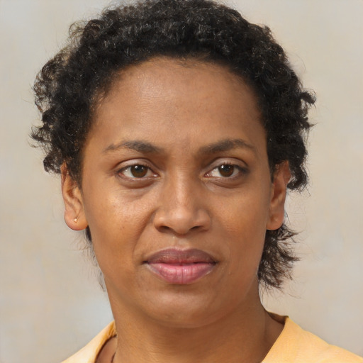 Joyful black adult female with short  brown hair and brown eyes
