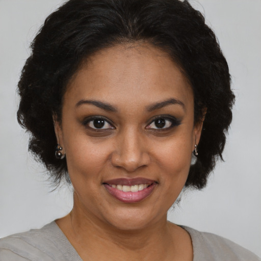 Joyful black adult female with short  brown hair and brown eyes