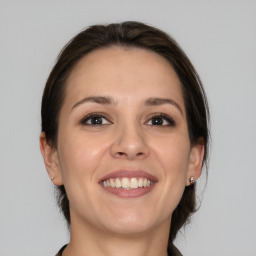 Joyful white young-adult female with medium  brown hair and brown eyes