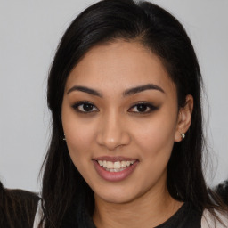 Joyful latino young-adult female with long  brown hair and brown eyes