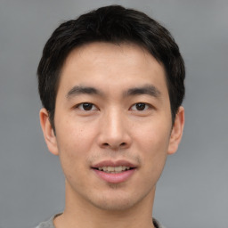 Joyful asian young-adult male with short  black hair and brown eyes