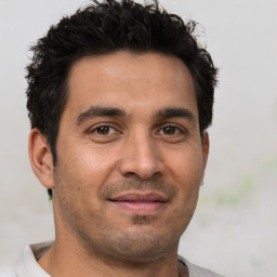 Joyful young adult male with brown eyes and short brown hair