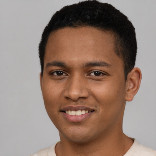 Joyful black young-adult male with short  brown hair and brown eyes