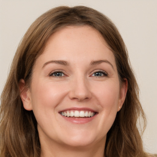 Joyful white young-adult female with long  brown hair and grey eyes