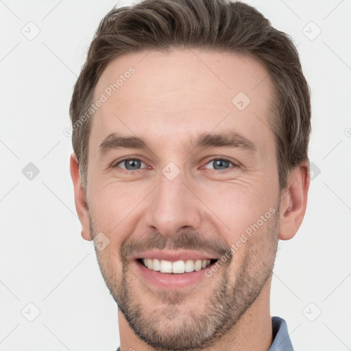 Joyful white young-adult male with short  brown hair and grey eyes