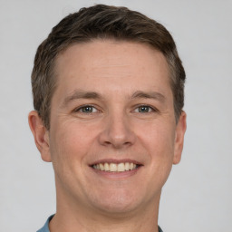 Joyful white adult male with short  brown hair and grey eyes