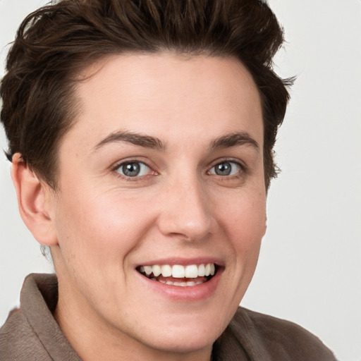 Joyful white young-adult female with short  brown hair and grey eyes