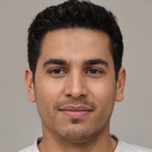 Joyful latino young-adult male with short  brown hair and brown eyes