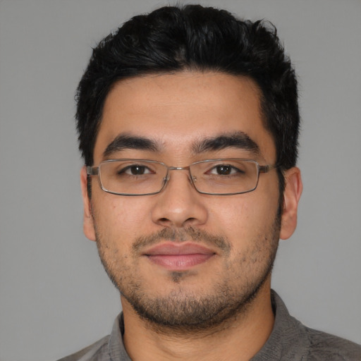 Joyful latino young-adult male with short  black hair and brown eyes